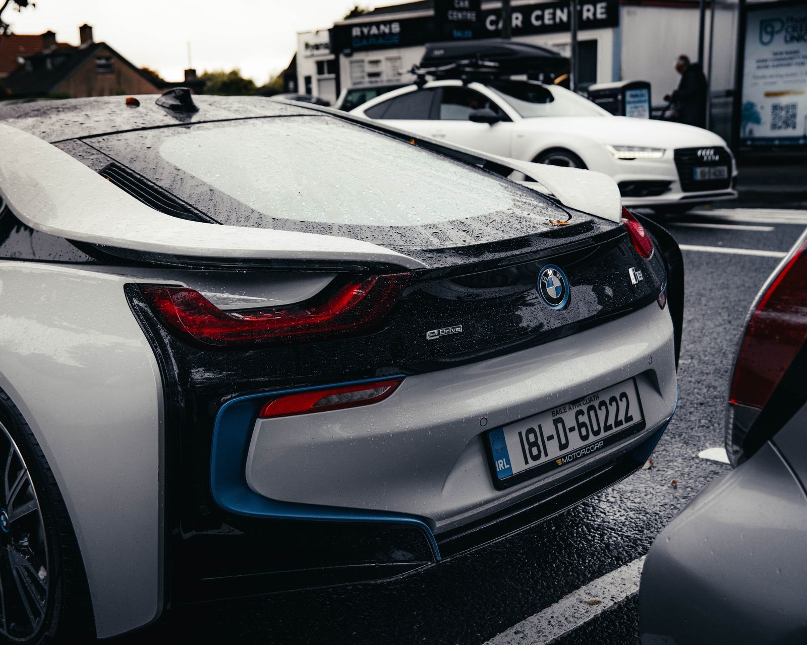Rear three-quarter view of the i8 in a car park.