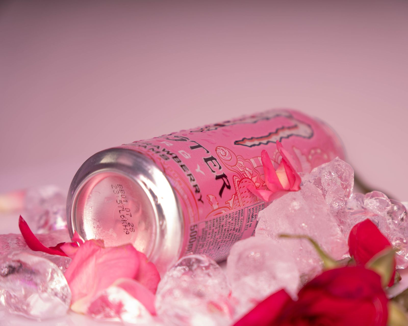 The can lying on its side in ice and petals.